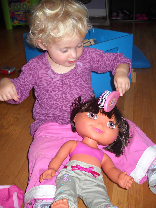 Girl brushing doll's hair